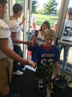 Football players welcoming students.
